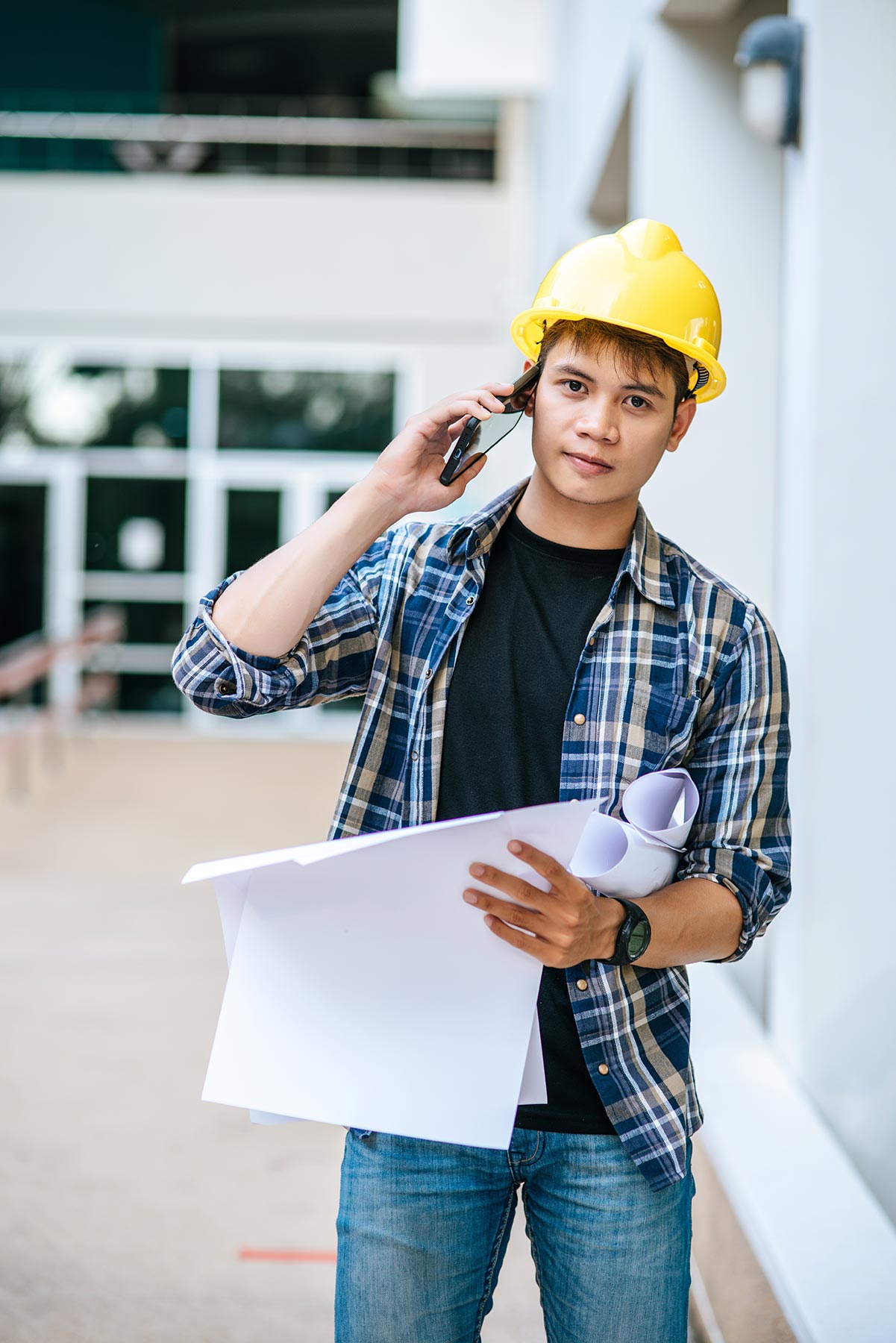 architects-hold-floor-plans-and-talk-on-the-phone-FMGGDF5.jpg